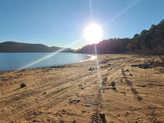 Western beach view with sun over Greers Ferry Lake